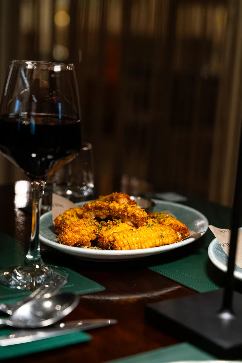 Wine being poured over a candlelit table at Mate's Restaurant