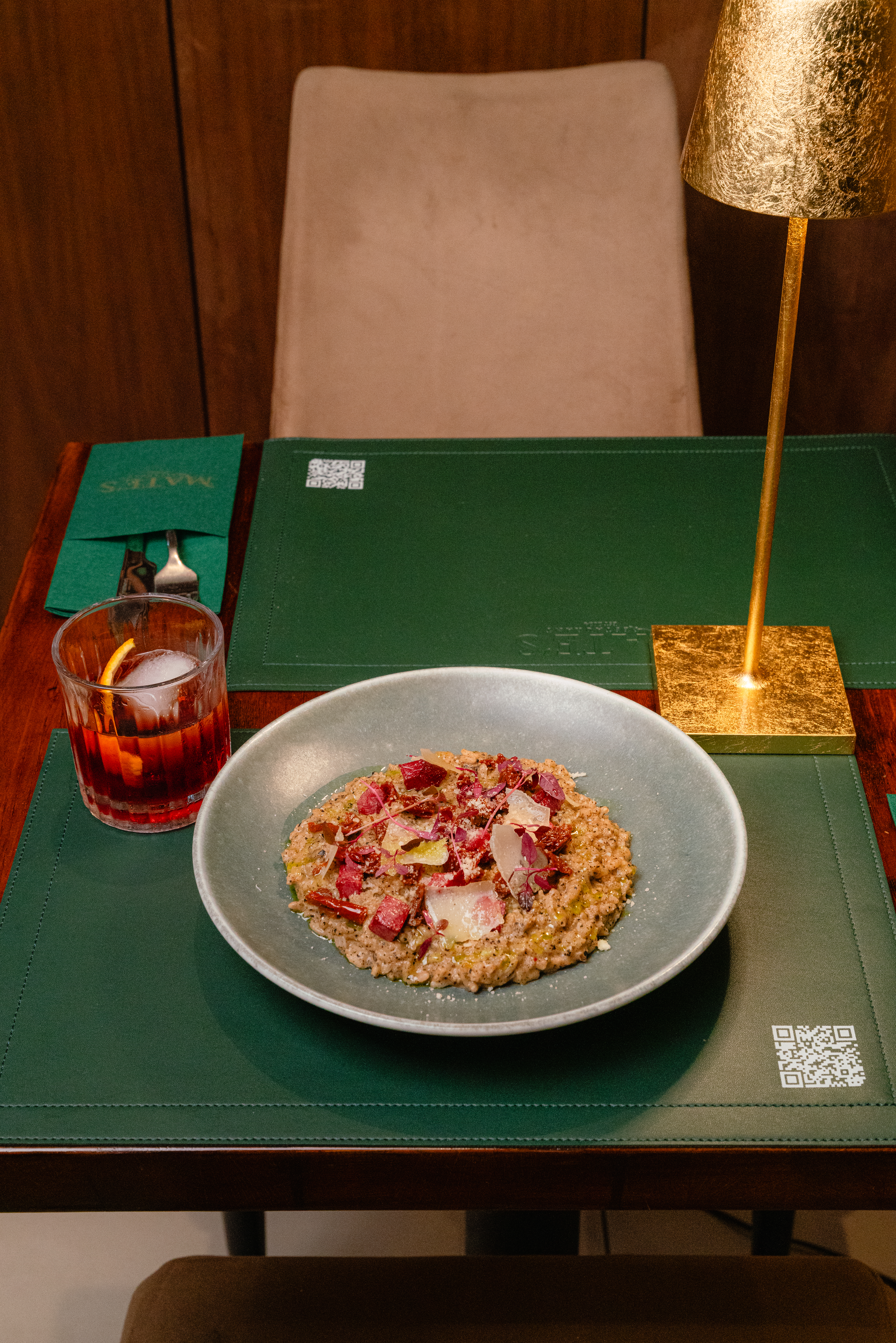 Risotto dish with cocktail on a green table at Mate's